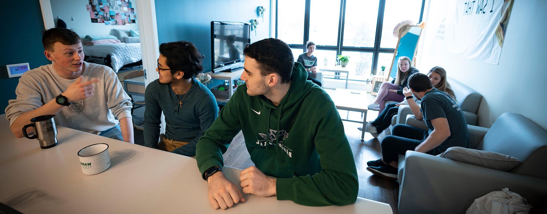 Group of students talking in Aspire Hall apartment